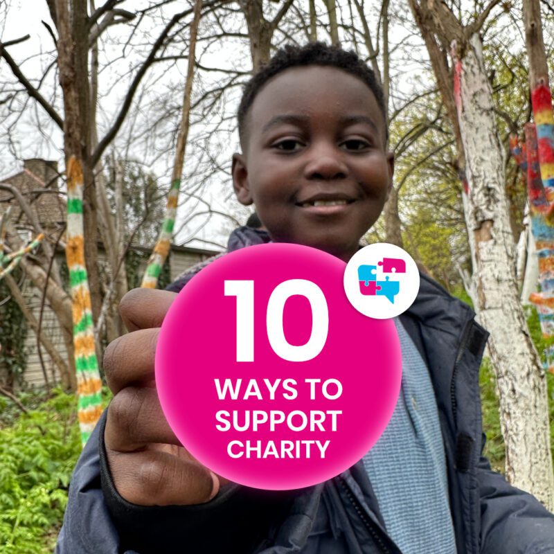 Boy in a wooded area holding pink circle with the Jigsaw4u logo which says 10 ways to support charity