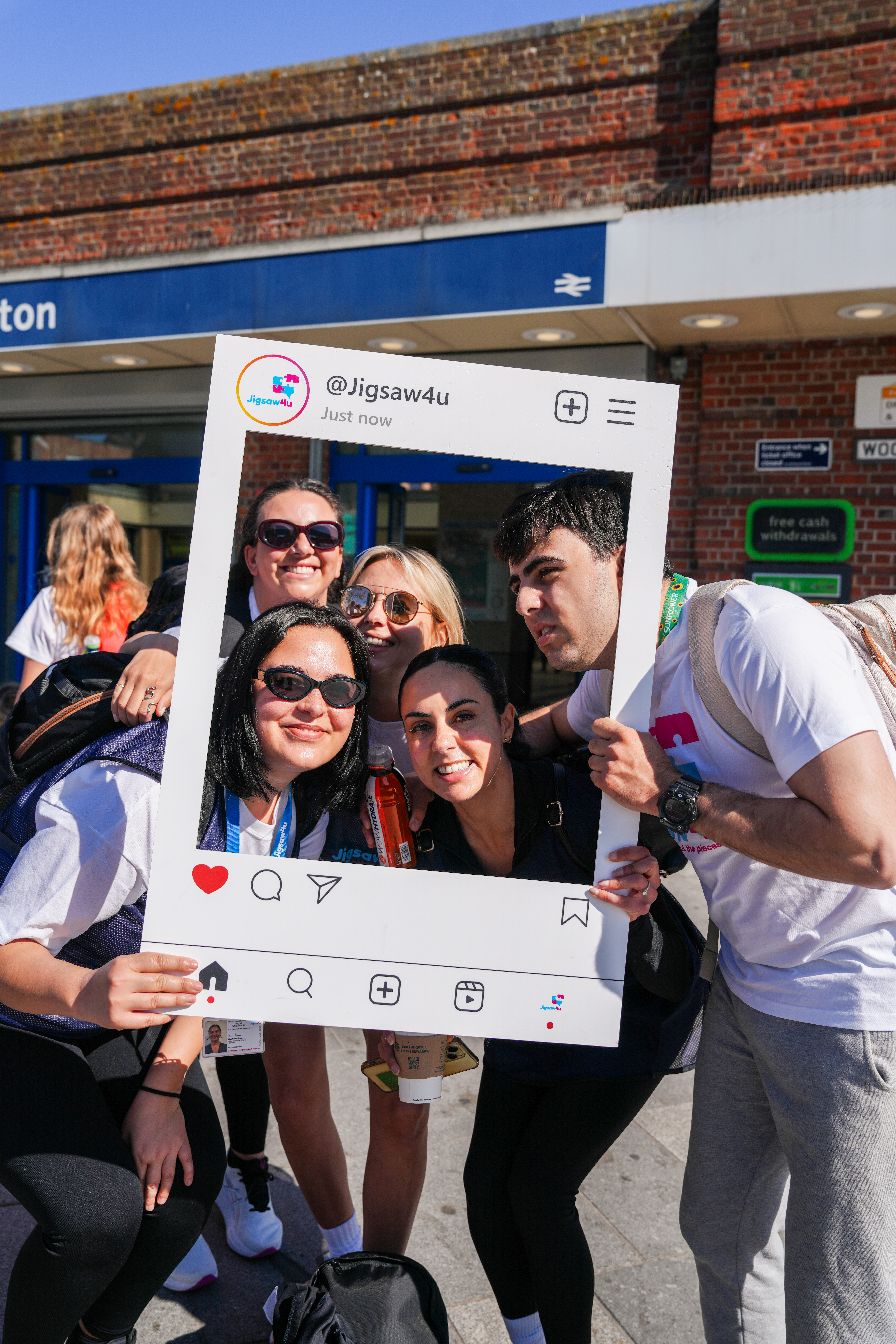 Four girls and a boy smiling inside of a Jigsaw4u selfie board, a few wearing Jigsaw4u tops