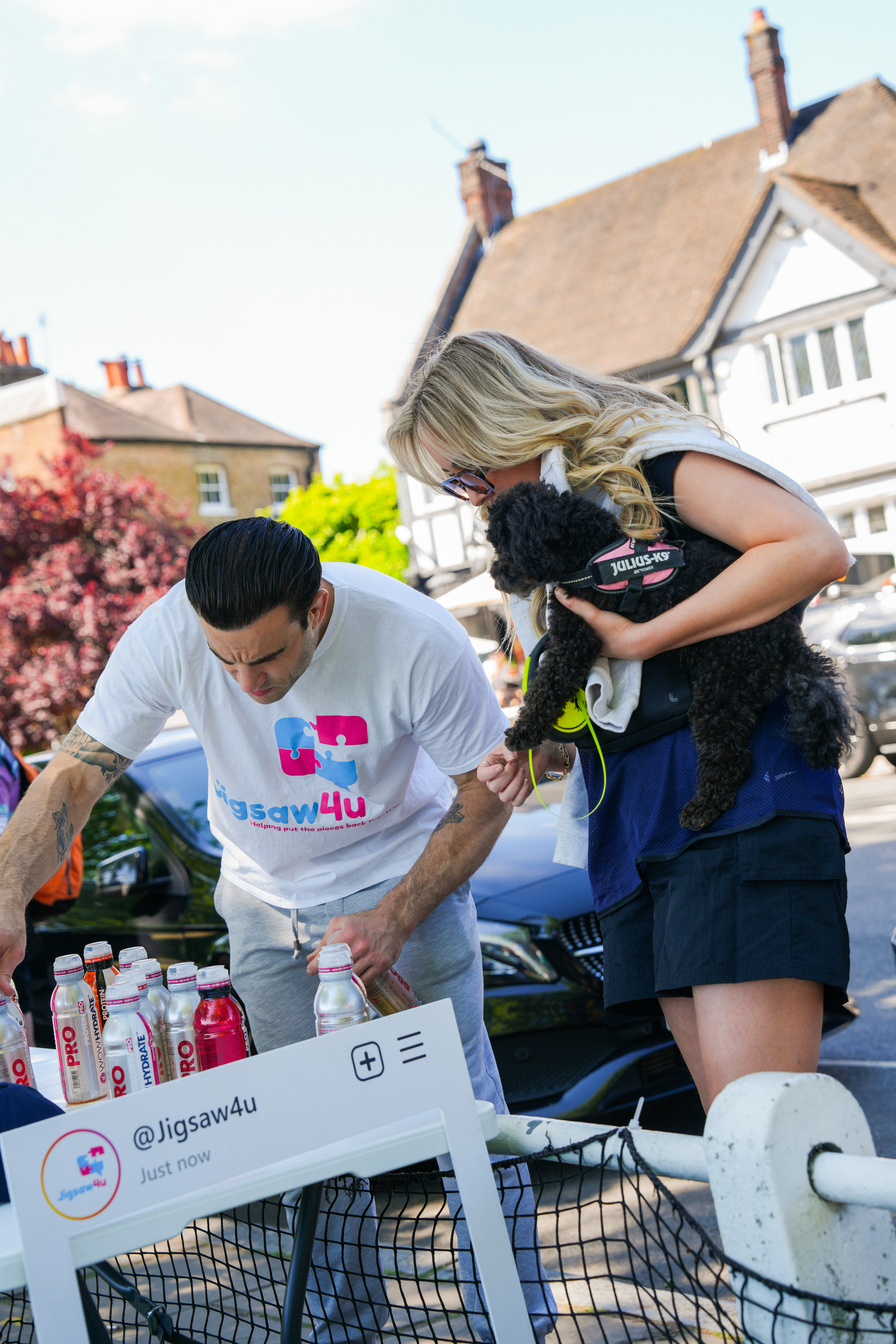 Stephen Loizou, CEO of Jigsaw4u, looking at WOW Hydrate bottles with SW London Bridge Walk walker and dog. At second rest stop on the walk near Kew Bridge.