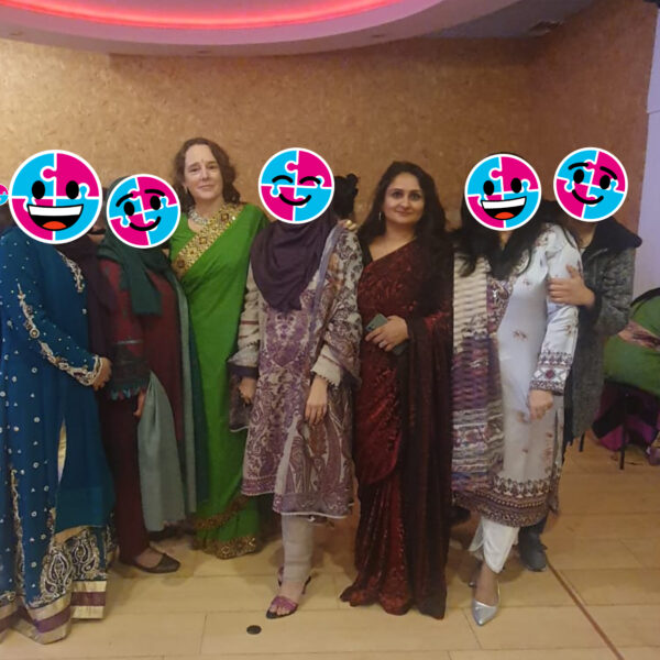 Staff for Helping Hands (Liz and Seema) standing with Helping Hands service users at the Diwali party